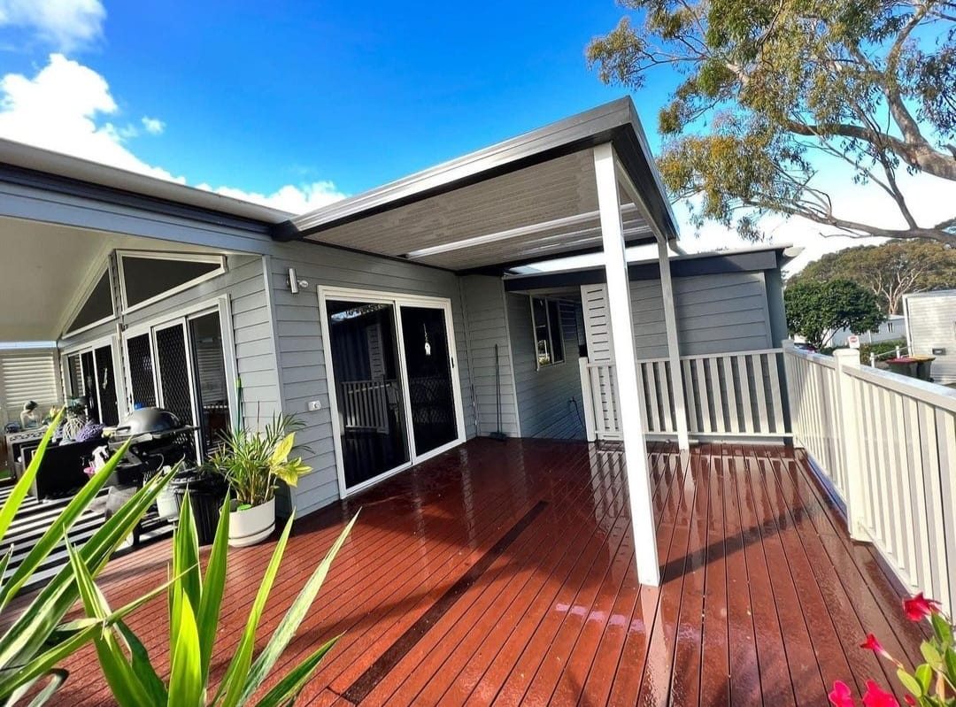Solid aluminum patio cover attached to a home over a rain-protected deck